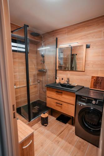 a bathroom with a sink and a washing machine at Appartement moderne et élégant in Saint-Denis