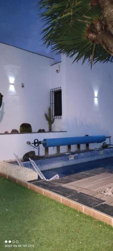 a blue bench in front of a building with a pool at LUXURY VILLA OCEAN VIEWS HEATED POOL private in Candelaria