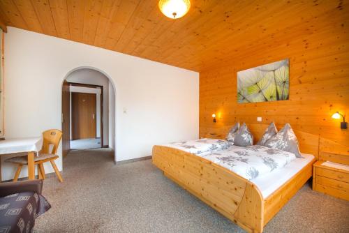 a bedroom with a bed in a wooden room at Pension Anderla in Oberau