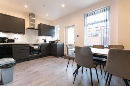 a kitchen and dining room with a table and chairs at Urmston House in Leigh