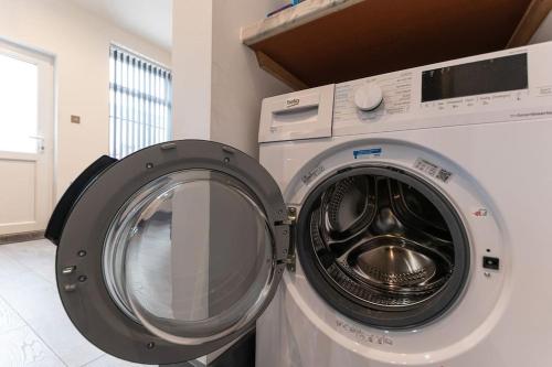 a washing machine and a dryer in a room at Urmston House in Leigh