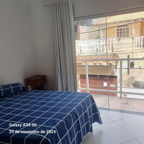 a bedroom with a bed and a large window at Aconchego do peró in Cabo Frio