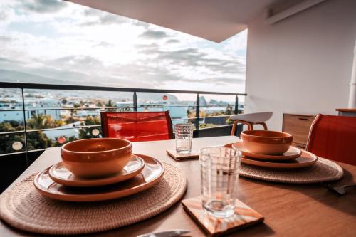 a table with two cups and plates on it with a view at Appartement moderne et élégant in Saint-Denis