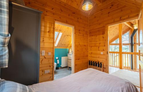 una camera da letto in una baita di tronchi con letto di Cherry Tree Lodge a Inverness