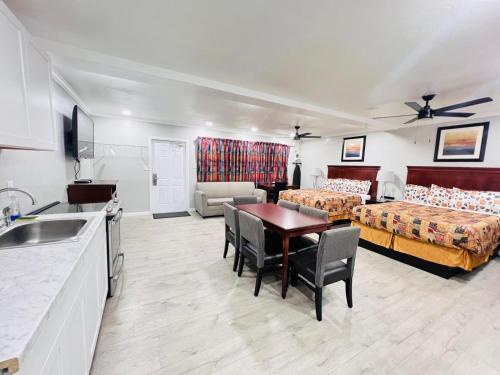 a hotel room with two beds and a table and a kitchen at Sunshine Inn & Suites Venice, Florida in Venice