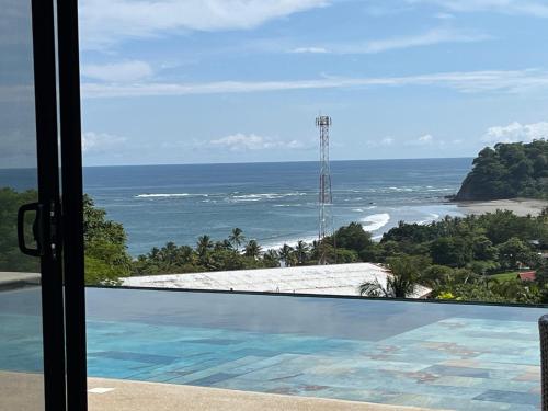 a view of the ocean from a resort swimming pool at Cima Del Mar in Sámara