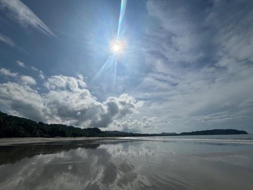 a sun is reflecting in the water on a beach at Cima Del Mar in Sámara