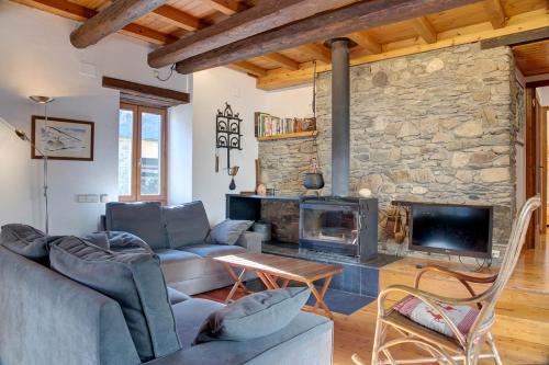 ein Wohnzimmer mit Couch und Kamin in der Unterkunft Casa Parrot - Jardín privado y balcón con vistas by Eth Flòc in Gessa