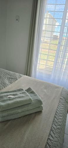 a bed with a tray on it next to a window at Armonía in Bella Unión