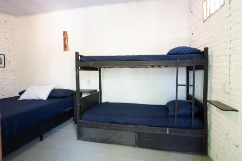 two bunk beds in a room next to a brick wall at Pipa Surf House in Pipa