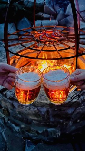 two glasses of tea in front of a fire at Farma František in Stachy