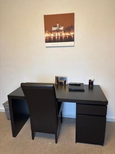 a black desk with a laptop on top of it at Hotel La Chaumiere in Asse