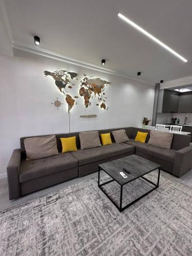 a living room with a couch and a map on the wall at Coco Chanel Apartment in Bishkek in Bishkek