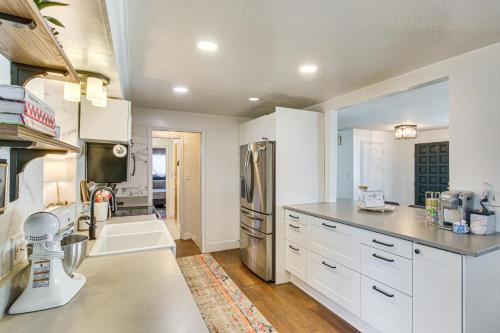 a kitchen with white cabinets and a stainless steel refrigerator at Family Home with Games and Fenced Yard in South Ogden in South Ogden