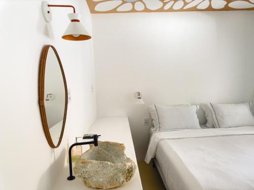 a bedroom with a mirror and a rock next to a bed at Pousada Vilab in Arraial d'Ajuda