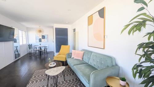 a living room with a blue couch and yellow chairs at Ocean View 1 Bedroom Manhattan Beach in Manhattan Beach