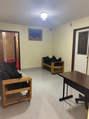a living room with two beds and a table at H one Hotel in Goiânia