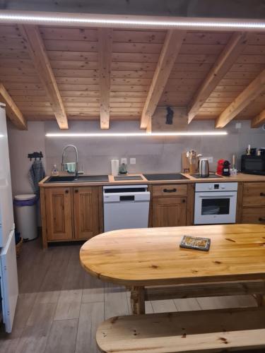 une cuisine avec des armoires en bois et une table en bois dans l'établissement Appartement luxueux, à Séez