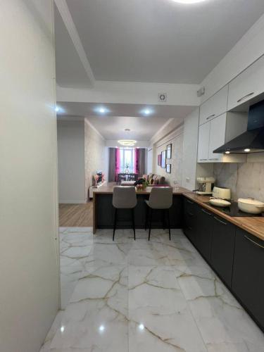a large kitchen with a counter and chairs in it at Coco Chanel Apartment in Bishkek in Bishkek