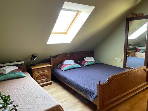 KernavėにあるGallery Guest Roomsの屋根裏のベッドルーム(ベッド2台、鏡付)