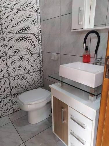 a bathroom with a toilet and a sink and a shower at Casa com Piscina e ampla area de festas in Barra Velha