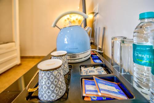 a counter top with a tea kettle and containers on it at Hotel Pajaros Blu in Calangute