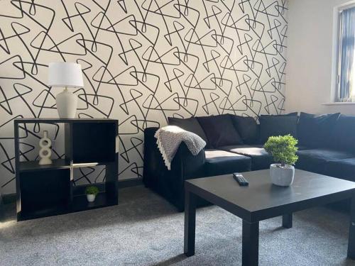 a living room with a blue couch and a table at Stylish 3-Bedroom House in Warrington - Sleeps 5 in Warrington