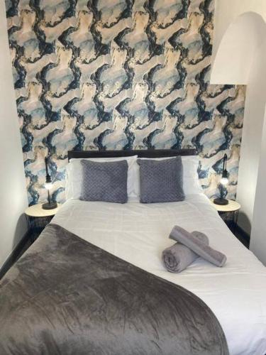 a bedroom with a bed with two pillows and a wall at Stylish 3-Bedroom House in Warrington - Sleeps 5 in Warrington
