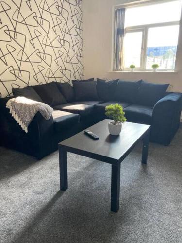 a living room with a blue couch and a coffee table at Stylish 3-Bedroom House in Warrington - Sleeps 5 in Warrington