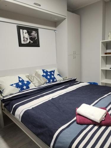 een slaapkamer met een bed met blauwe en witte lakens bij Weekend varijanta Plus in Novi Sad