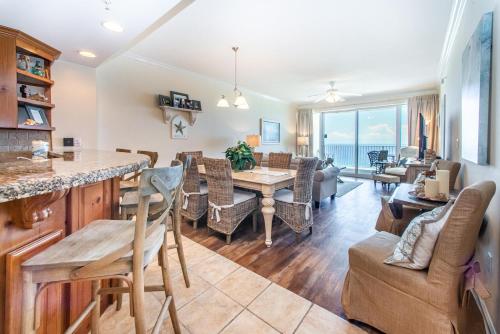 a dining room and living room with a view of the ocean at Boardwalk 1502 in Panama City Beach
