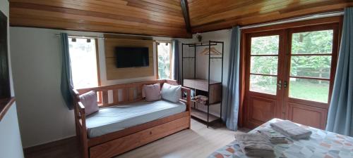 a bedroom with a bed and a tv and a window at Rancho Pôr Do Sol in Arapeí