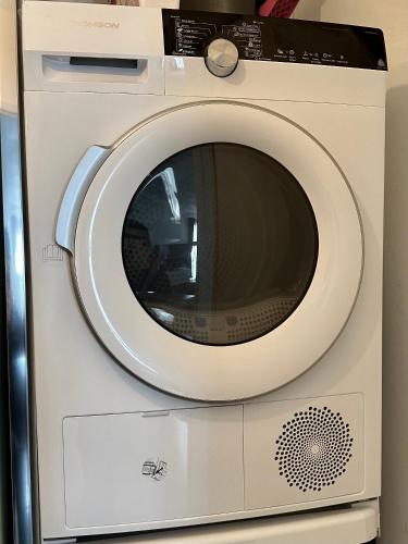 a white washing machine with a silver door at Appt Vue Place de Toscane - 4min Disneyland-PARIS in Serris
