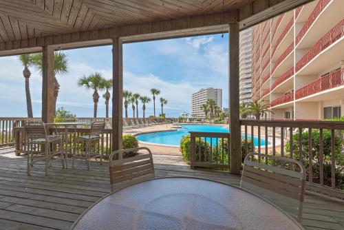 a balcony with a table and chairs and a pool at Hidden Dunes 304 in Panama City Beach