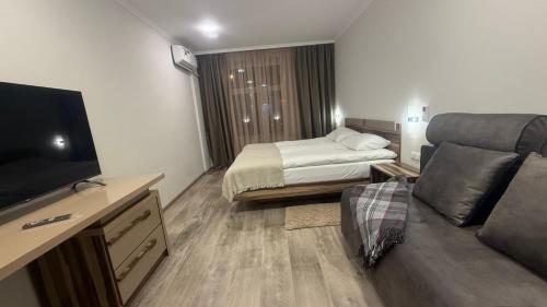 ein Hotelzimmer mit einem Bett und einer Couch in der Unterkunft VIVA Aparts in Gjumri