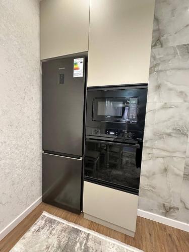 a kitchen with a refrigerator and a microwave at Coco Chanel Apartment in Bishkek in Bishkek