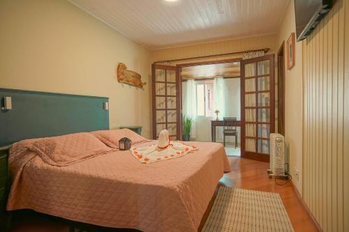 a bedroom with a bed with a hat on it at Recanto Due Fratelli in Campos do Jordão