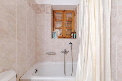 a bathroom with a bath tub with a shower curtain at Stone Mountainhouse near Kalavryta, North Peloponnese, Greece in Dhoumená