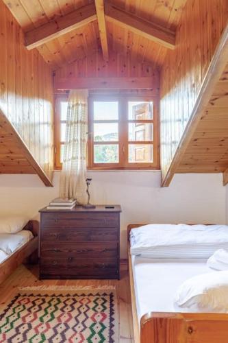 a bedroom with two beds and a dresser and a window at Stone Mountainhouse near Kalavryta, North Peloponnese, Greece in Dhoumená