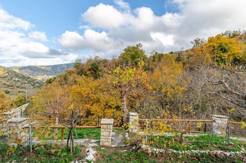 a view of a hill with trees and a fence at Stone Mountainhouse near Kalavryta, North Peloponnese, Greece in Dhoumená