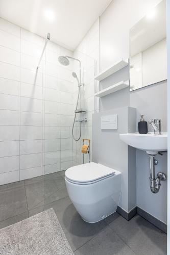 a white bathroom with a toilet and a sink at Baltic Cozy Spot in Palanga