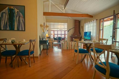 a room with tables and chairs and a living room at Recanto Due Fratelli in Campos do Jordão