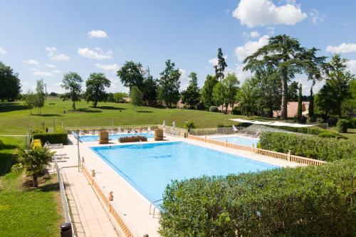 une grande piscine dans un parc arboré dans l'établissement Magnifique villa avec piscine et climatisation, à Lombez
