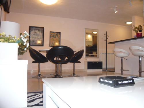 barbería con taburetes negros en una habitación en G&B Apartments, en Trogir