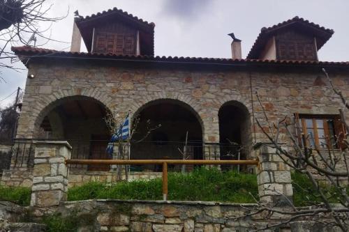 an old stone house with a fence in front of it at Stone Mountainhouse near Kalavryta, North Peloponnese, Greece in Dhoumená