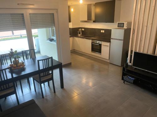 una cucina e una sala da pranzo con un tavolo e una televisione di Grand 2 pièces Eurométropole de Strasbourg proche Europa Park avec terrasse a Plobsheim