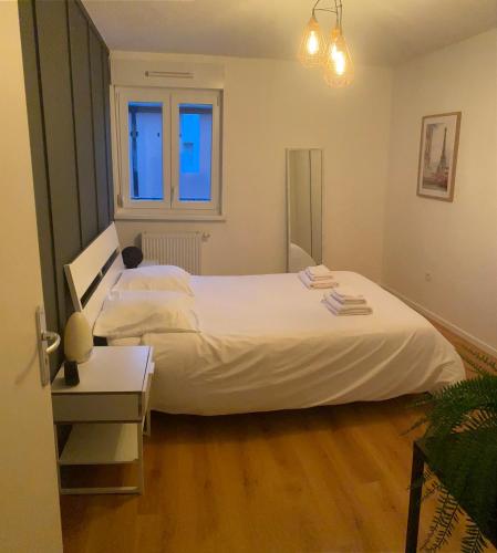 une chambre avec un grand lit blanc et un parquet dans l'établissement Grand 2 pièces Eurométropole de Strasbourg proche Europa Park avec terrasse, à Plobsheim