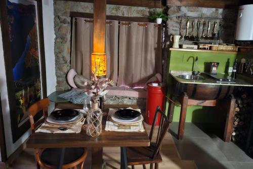 a table with chairs and a sink in a kitchen at cabaña do rei in Betán