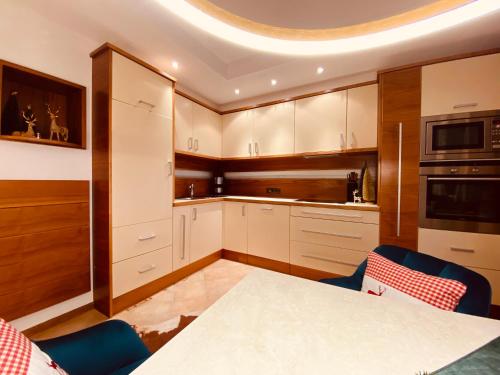 a kitchen with white cabinets and a table at Sonnalm Panoramablick in Rohrberg