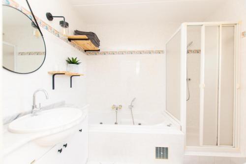 a white bathroom with a tub and a sink at Magnifique villa avec piscine et climatisation in Lombez